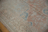 Distressed Oushak rug pile detail, showing worn floral blossoms and visible knot heads.