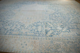 Faded powder blue and ivory floral motifs with distressed texture on a vintage Heriz rug.
