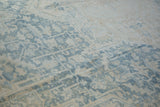 Powder blue and ivory floral design on distressed vintage Heriz carpet pile.