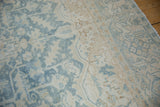 Distressed texture of powder blue and ivory floral motifs on a vintage Heriz carpet.