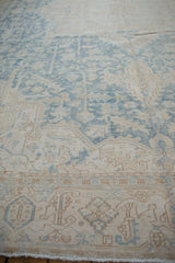 Textured detail of distressed vintage Heriz carpet, faded powder blue and ivory patterns, even wear.