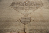Vintage Oushak rug detail: abrashed geometric vines in beige, camel, and coffee brown.