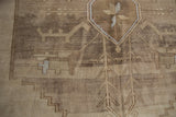 Close-up of vintage Oushak rug's geometric medallion, germinating vines, and distressed abrash.