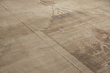 Abrashed beige and camel geometric patterns on a distressed vintage Oushak carpet, short pile.