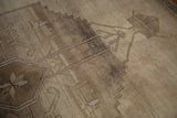 Distressed vintage Oushak detail: abrashed geometric vines and floral shapes in beige and camel.