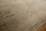 Distressed Oushak pile texture in beige with geometric border and subtle blue accents.