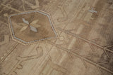Vintage Oushak rug detail: geometric star medallion, germinating vines on abrashed beige field.