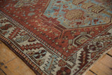 Vintage distressed Hamadan rug corner, showing chestnut, denim blue, ivory serrated leaf border.