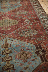 Distressed dusty denim blue field with geometric floral bouquets and pinwheel motifs.
