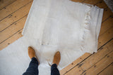 Nuanced ivory texture of a vintage Turkish flatweave runner, showing natural edging and feet.