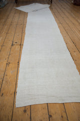 Close-up of vintage Turkish flatweave runner, showing textured ivory abrash and nuanced edging.