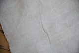 Nuanced ivory hand-spun Turkish flatweave texture with abrash and visible selvage.