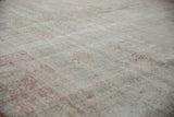 Faded pale raspberry floral patterns with visible foundation and worn knot heads.