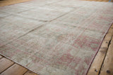Distressed vintage Sparta carpet with worn pale pink pile and intact side selvage.