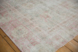 Close-up of the distressed Sparta carpet's worn texture, with faded raspberry pink, grey, and ivory hues.
