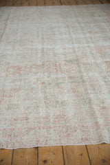 Distressed Sparta carpet pile with visible foundation, faded pink and grey floral patterns.