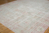 Vintage distressed Sparta carpet corner, faded pink and ivory floral motifs, with visible wear.