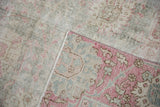 Distressed Sparta carpet's reverse foundation and worn floral pile in pale pink, grey.