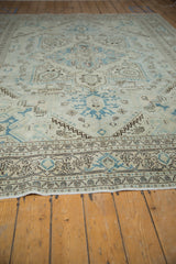 Vintage distressed Sparta carpet corner with ivory, blue, and brown geometric field and detailed border.