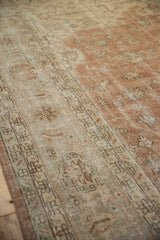 Distressed Sparta rug detail, showcasing worn texture and faded floral vinery in sandalwood and ivory.