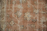 Close-up of distressed Turkish Sparta carpet: sandalwood field, ivory serrated leaves, and significant wear.