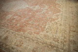 Distressed corner of a Sparta rug, showing sandalwood and ivory geometric border patterns.