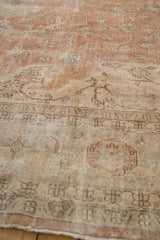 Distressed vintage Sparta carpet detail: worn sandalwood and beige pile with floral vinery.