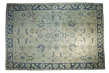 Distressed vintage Oushak carpet with a geometric allover design in soft sea foam green, beige, and dusty navy blue.