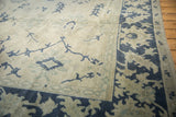 Textured knot heads and sharp palmette designs on a distressed Oushak carpet's corner.