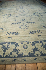 Low angle view of a distressed Oushak carpet, focusing on the worn pile and dusty blue geometric motifs.