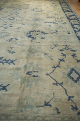 Low-angle view highlighting the even wear and distressed texture of a vintage Oushak carpet.