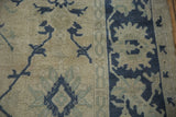 Evenly worn knot heads on a vintage Oushak in dusty navy and beige tones.
