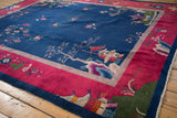 Nichols Art Deco carpet with navy field, fuchsia border, pictorial trees and lotus motifs.