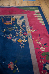 Vintage Art Deco carpet: Navy field with blossoming tendrils, magenta border, visible knots.
