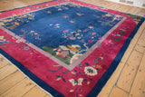 Hand-knotted Chinese rug corner, navy blue and cochineal red borders, floral vinery, white knot speckles.