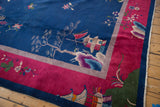 Corner detail of the vintage Art Deco rug with pictorial trees, navy, and cochineal red.