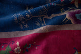 Art Deco carpet close-up: navy blue field, ivory tendrils, magenta florals, with white knots.