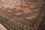 Distressed vintage Ersari carpet showing dusty chestnut guls and geometric border.