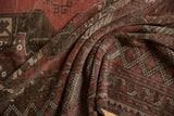 Distressed pile texture of a vintage Ersari carpet, showing geometric guls in dusty reds and browns.