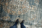 Distressed Sparta carpet in denim blue with floral sprays, ivory, pale gold, and visible foundation.