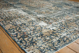 Distressed vintage Sparta rug showing worn denim blue floral sprays and exposed foundation.