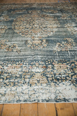 Distressed denim blue pile with ivory floral sprays on a vintage Sparta rug.