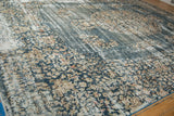 Distressed texture on a vintage Sparta carpet, showing denim blue and pale gold florals.