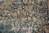 Distressed denim blue Sparta carpet, faded ivory and pale gold floral sprays, exposed foundation.