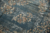 Distressed denim blue Sparta rug with ivory floral sprays, showing foundation wear.