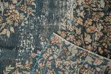 Distressed denim blue Sparta carpet showing faded floral pile, exposed foundation, and patterned reverse.