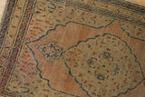 Vintage Tabriz rug detail showing pale dusty navy curvilinear motifs, beige tones, and even wear.
