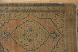 Vintage Tabriz rug corner: book cover spandrel detail, navy border, and visible pile wear.