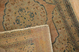 Vintage Tabriz rug's folded edge, showing faded antique ivory pile, faint foundation, and backing design.
