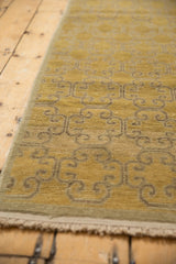 Distressed gold and beige floral panel motif on the Khotan rug runner's worn pile.